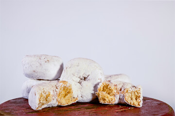 five white powdered doughnuts one cut in half isolated on white background