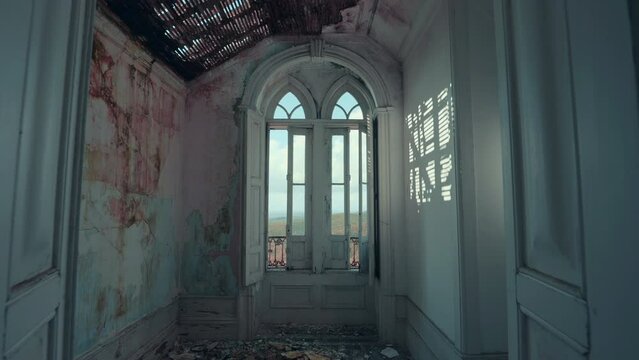 Ruined room with gothic style arch windows of an abandoned house at sunset