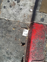 Four of spades playing card found on the street next to a red curb