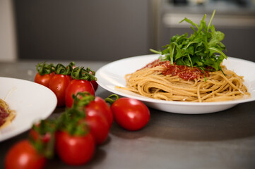 Food background with classic Italian cuisine dish. Pasta capellini with tomatoes, arugula leaves and parmesan cheese. Copy advertising space. Classic Italian cuisine dish.