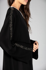 an Arab lady graces the scene in a traditional Arabic abaya