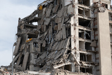Image of a heavily damaged building with collapsed walls and debris, illustrating destruction and aftermath of a disaster.