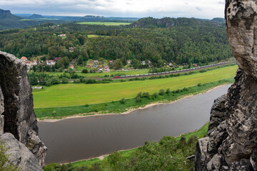 Obraz premium A river with a train passing by. The train is long and has many cars