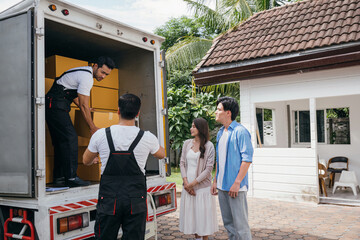 Team of workers assists a couple in moving into their new home. Together they unload and lift cardboard boxes showcasing professional and efficient delivery service. Moving Day Concept