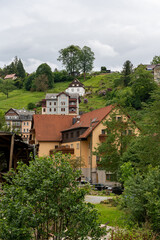 A small town with houses and trees in the background. The houses are brown and white. The sky is cloudy