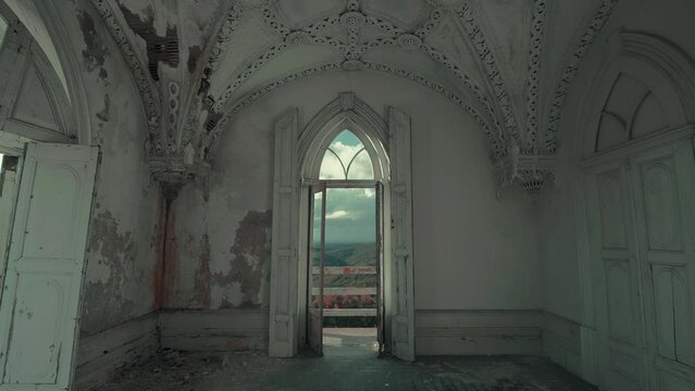 Decaying room with gothic style arch balcony of an abandoned house at sunset (ProRes 422HQ, 4K)