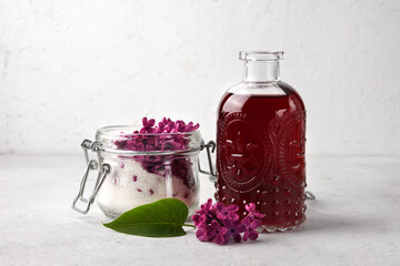 Preparation of syrup from the flowers of lilac. Glass jar. White background. Copy space