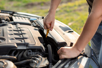 Man hands checking oil level in engine before trip or journey by automobile, closeup. Car check...