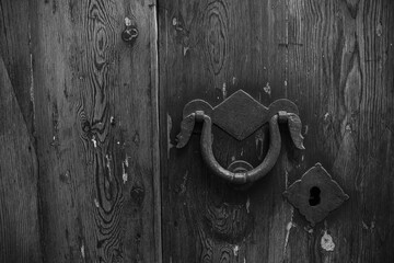 Vintage antique door with keyhole and ring handle. Antique wooden door with a forged metal lock and handle