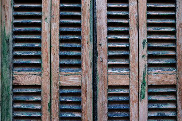 Wooden shutters with green paint residue. Peeling wooden shutters close-up, background, pattern