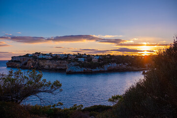 Beautiful panoramic view of Santanyi, Mallorca, Spain at golden hour of sunset. A town in the rays of the setting sun, beautiful sky and calm sea