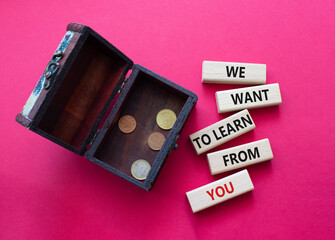 We want to learn from you symbol. Wooden blocks with words We want to learn from you. Beautiful red background with box with coins. Business and We want to learn from you. Copy space.