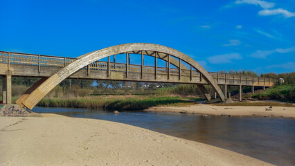 Naklejka premium Detalhe de ponte de madeira sobre o rio, zona protegida. 