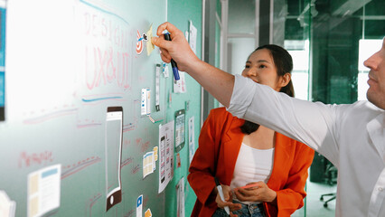 Portrait of group of businesspeople putting sticky notes on glass board. Professional business team...