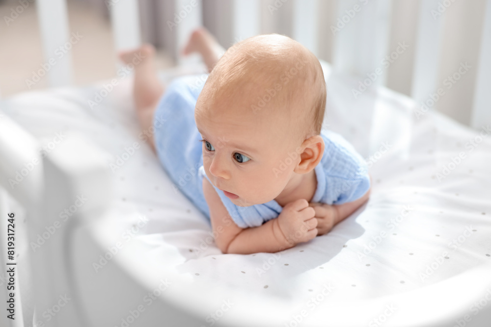 Sticker Cute little baby lying in crib at home