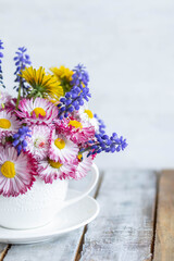 Summertime inspiration, colourful floral composition for Mother's or Women's day, anniversary, birthday. Greeting holiday card template with summer fresh bright daisy flowers in a white porcelaine mug
