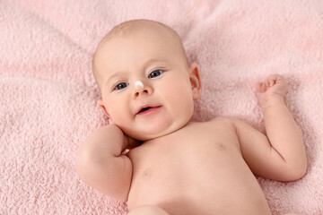 Cute little baby with cream on nose on pink blanket, above view