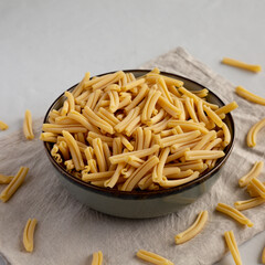 Dry Casarecce Pasta in a Bowl, side view.