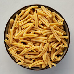 Dry Casarecce Pasta in a Bowl, top view. Flat lay, overhead, from above.