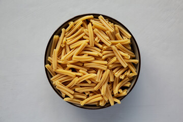 Dry Casarecce Pasta in a Bowl, top view. Flat lay, overhead, from above.