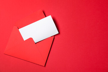 Letter envelope with card on red background, top view. Space for text