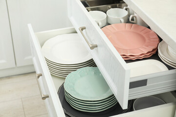 Clean plates and bowls in drawers indoors