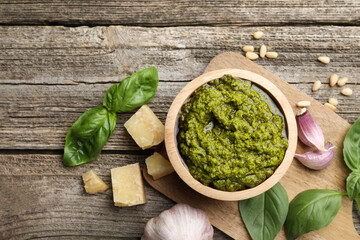 Tasty pesto sauce, basil, pine nuts, cheese and garlic on wooden table, top view