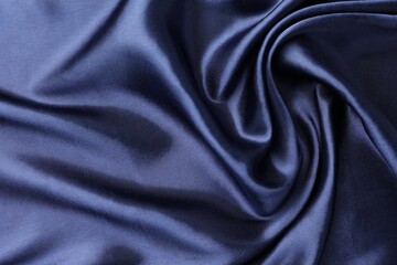 Fototapeta premium Crumpled dark blue silk fabric as background, top view