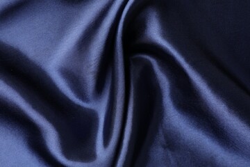 Crumpled dark blue silk fabric as background, top view