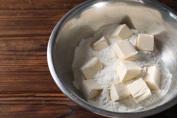 Making shortcrust pastry. Flour and butter in bowl on wooden table. Space for text