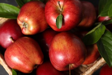 Fresh red apples with leaves in basket, closeup