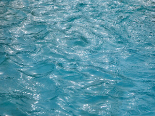 Agua azul,detalle de un piscina con reflejos de luz solar