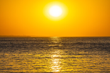 Sole verso il tramonto sul mare con riflessi dorati