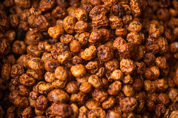 a pile of dry large orange tiger nuts wet with water and clean