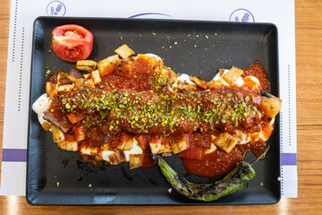 Turkish kebab with pistachios served with sliced pita bread, yoghurt and tomato sauce.