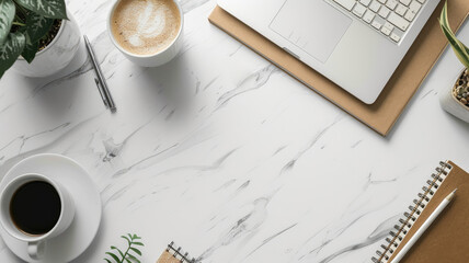 Modern workspace with laptop, coffee, plant, and notebook on marble desk