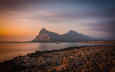 Sunrise on the paradise Tyrrhenian sea bay. San Vito lo Capo and Monte Monaco in far, Sicily, Italy. June 2023, long exposure picture