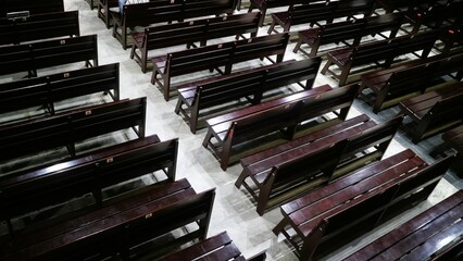 Rows of polished wooden benches in the church hall, suitable for religious or spiritual themes