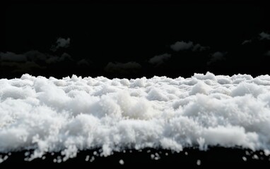 A long ridge of fluffy white snow isolated on a black background.