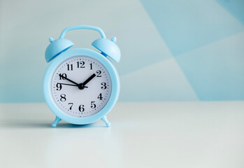 Blue alarm clock on blue background