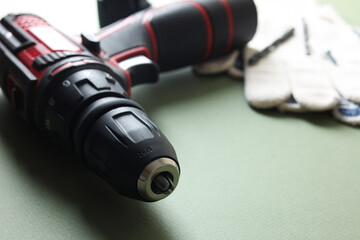 Electric screwdriver on pale green background, closeup. Space for text