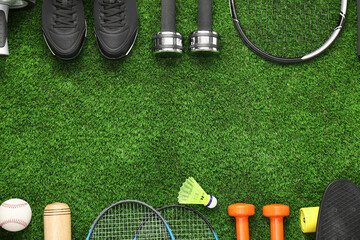 Fototapeta premium Different sports equipment on green grass, flat lay. Space for text