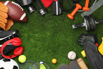 Frame of different sports equipment on green grass, flat lay. Space for text