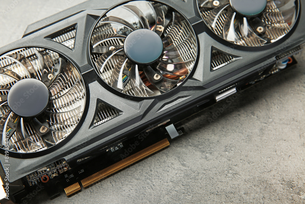 Aufkleber one computer graphics card on grey textured table, above view
