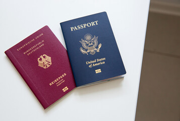 Close up of an American and German passports on white table