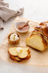 Homemade sliced challah bread with butter and honey