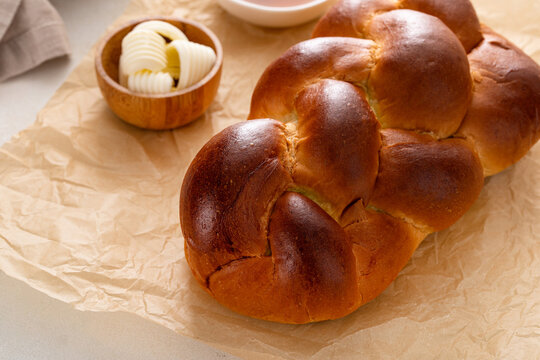 Homemade sliced challah bread with butter and honey