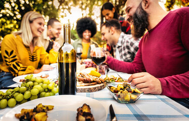 Happy friends having bbq dinner party in garden restaurant - Cheerful family drinking red wine...