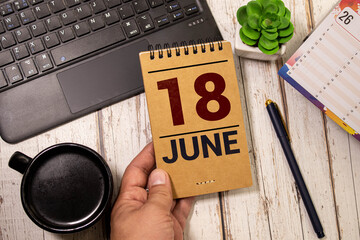 June 18 calendar date text on wooden blocks with blurred nature background.