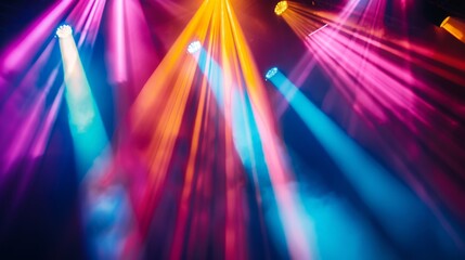 Close-up of stage spotlights casting colorful rays of light, adding depth and dimension to a concert atmosphere.